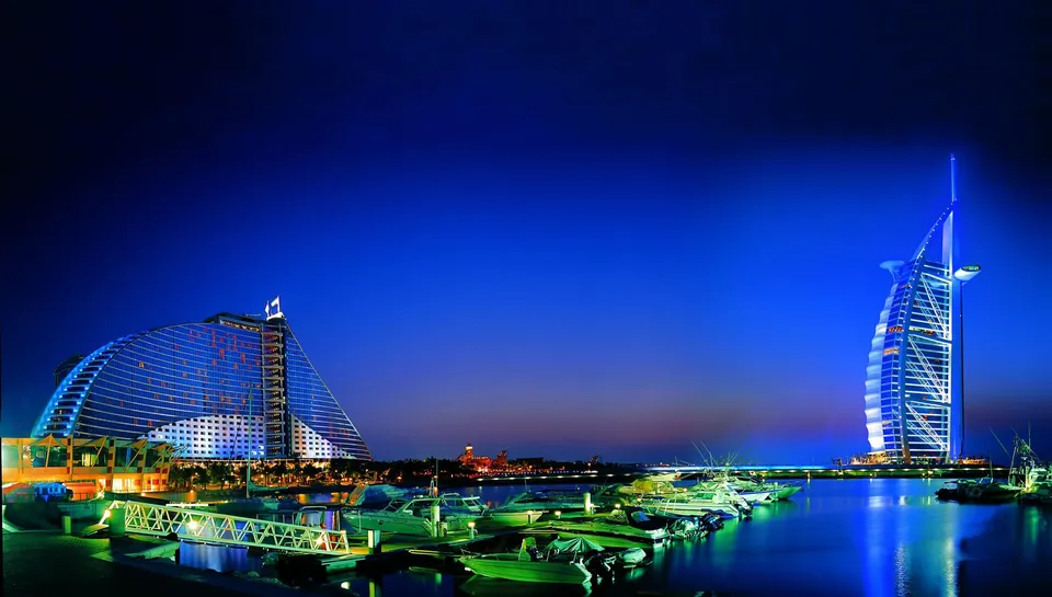 Burj Al Arab lit up at night beside Jumeirah Beach Hotel